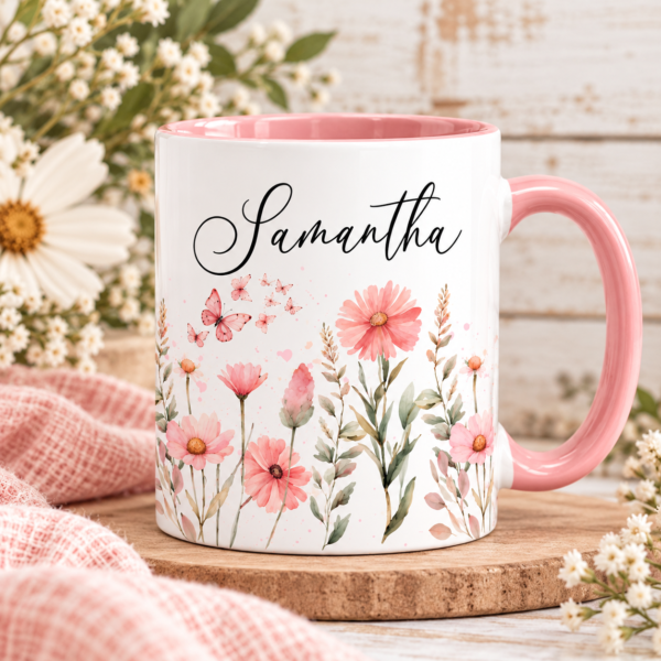 Pink watercolor floral mug wrap sublimation design displayed on a white coffee mug with a pink handle and interior, featuring pink flowers, delicate butterflies, and greenery with Samantha as an example name. Customers can add their own text after downloading.